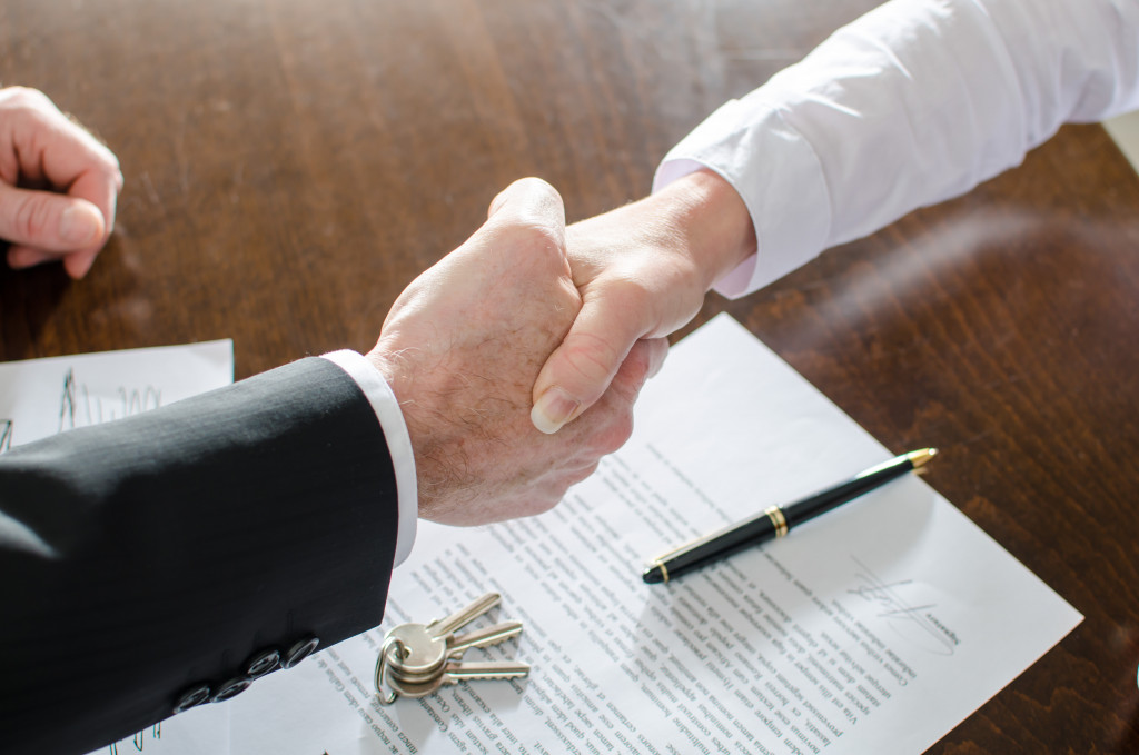 Estate agent shaking hands with his customer after contract signature