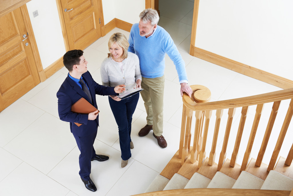 a couple with a real estate agent at an open house