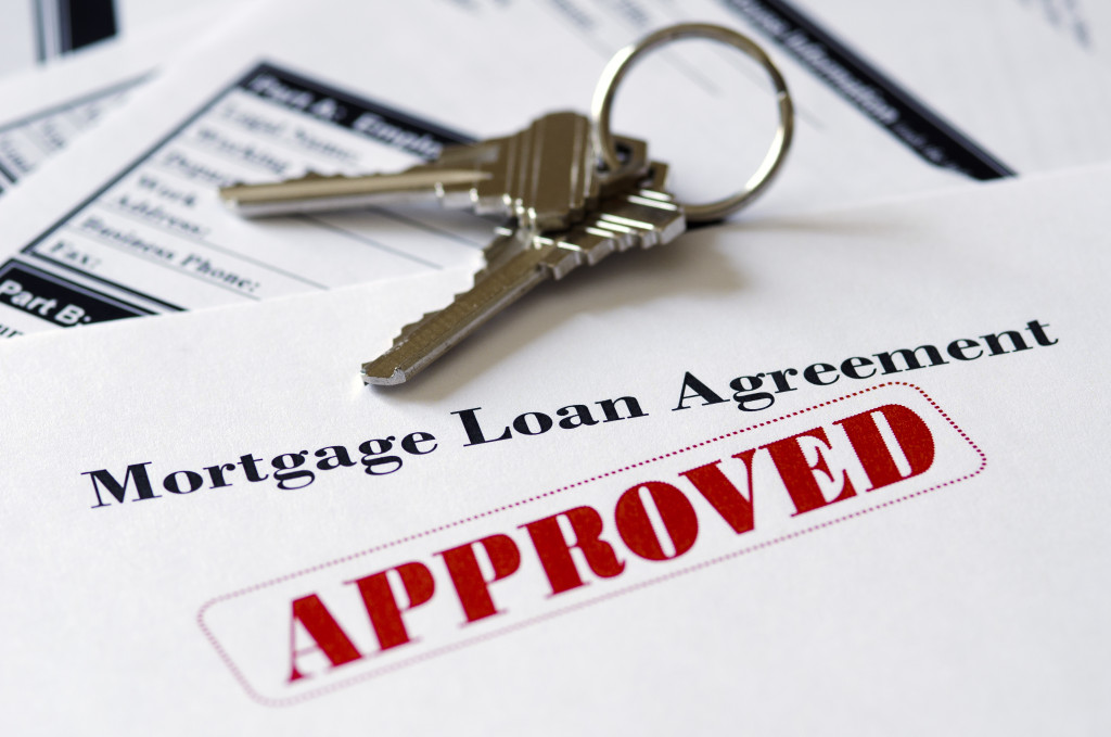 An approved mortgage loan application with house keys on top