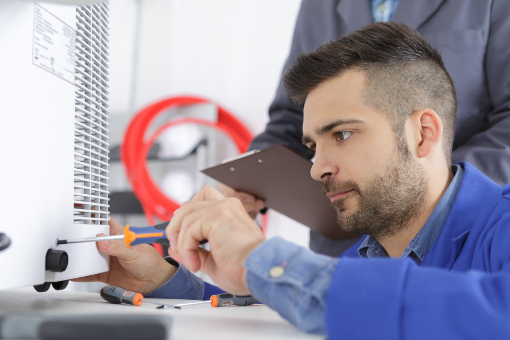 Technician checking the air conditioning unit of a house.