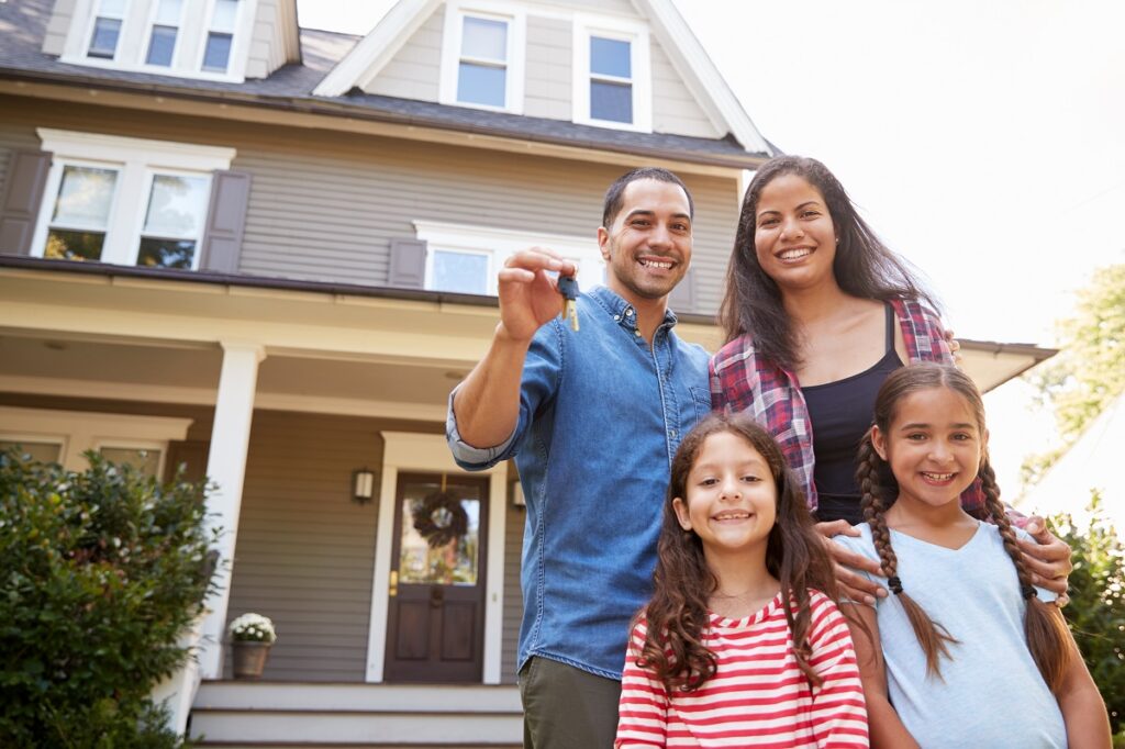 happy family holding a house key of their new home