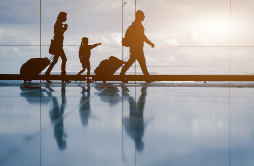 family walking in the airport with luggages in tow